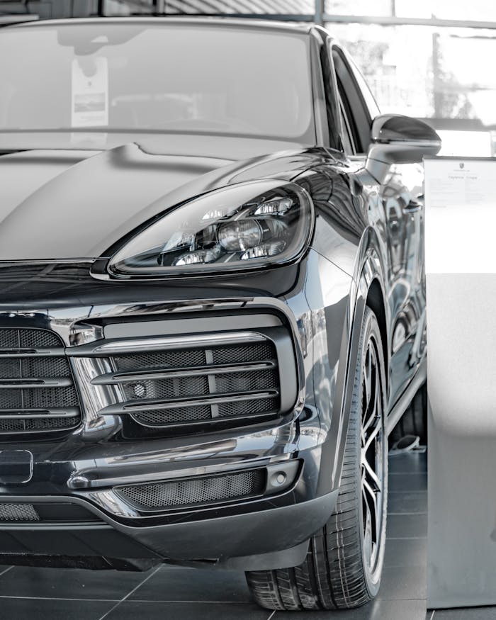 Sleek black luxury SUV displayed in a bright and modern showroom with natural lighting.