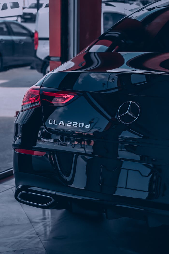 Sleek black Mercedes-Benz CLA 220d coupe showcased indoors with a luxury design.